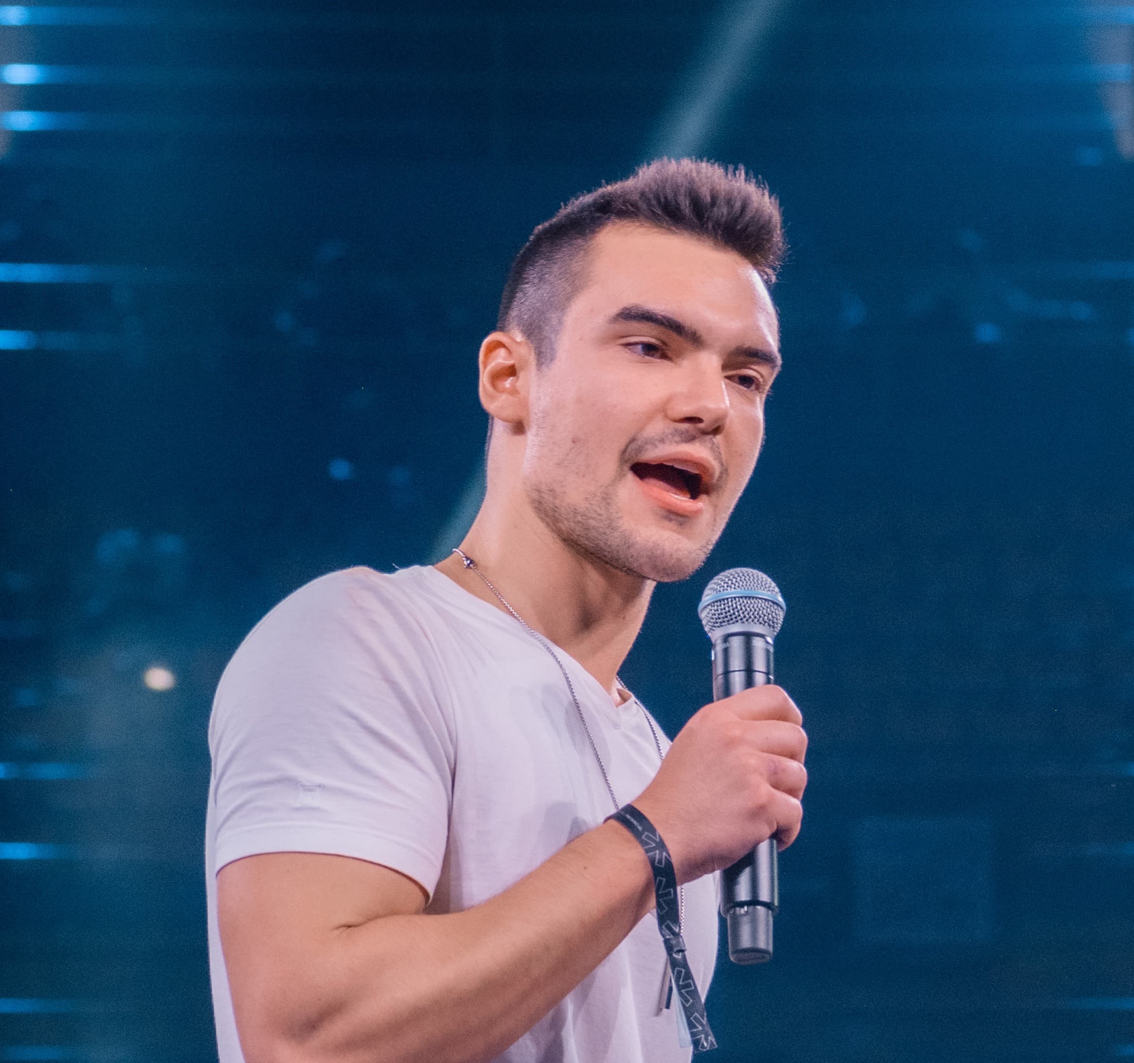 Breno Perrucho no palco, com microfone na mão